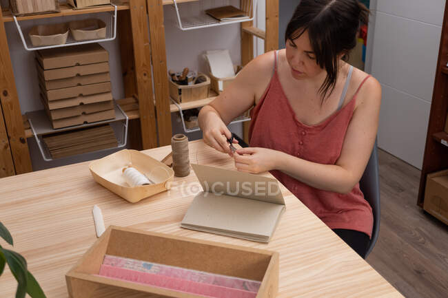 Giovane artigiana che lavora nel suo laboratorio di prodotti biologici — Foto stock