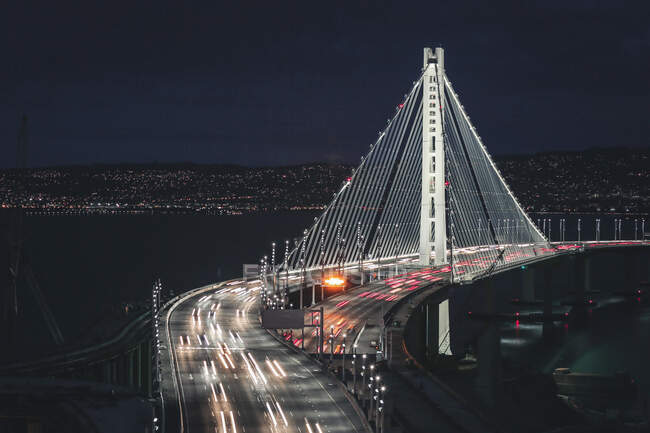 Вид на освещенный светофорами мост ночью — стоковое фото