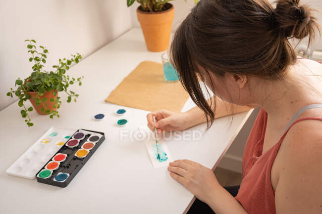 Женщина рисует акварелью в своей мастерской дома — стоковое фото