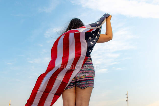 Visão traseira da mulher com bandeira americana — Fotografia de Stock