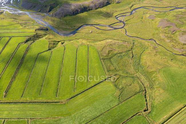 A river is flowing by rural land, seen from above. — Stock Photo