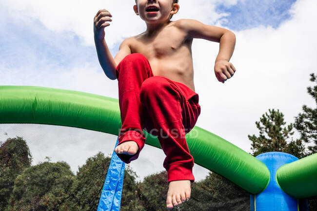 Ragazzo che salta su un parco giochi — Foto stock