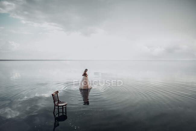 Elegante Frau stieg ins Wasser. Sonnenuntergang und Silhouette. Das Konzept der Einheit mit der Natur. Schweigen — Stockfoto