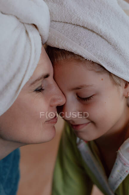 Jovem caucasiano mulher com sua filha, vestindo em toalha — Fotografia de Stock
