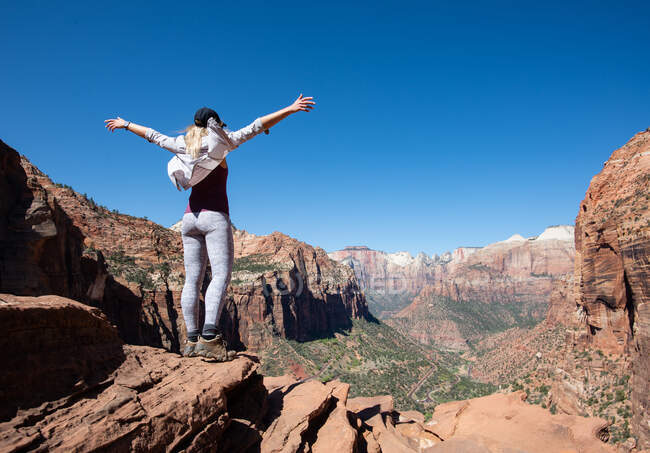 Chica con las manos arriba toma en vista del Parque Nacional Zion, Utah - foto de stock