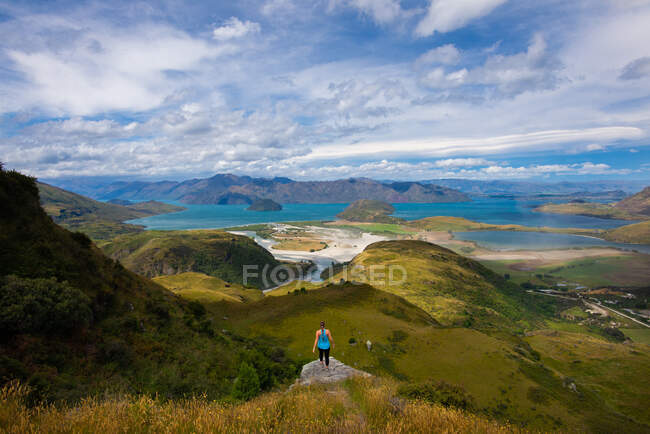 Menina no penhasco com vista para o exuberante ponto de vista do oceano em Wanaka Nova Zelândia — Fotografia de Stock