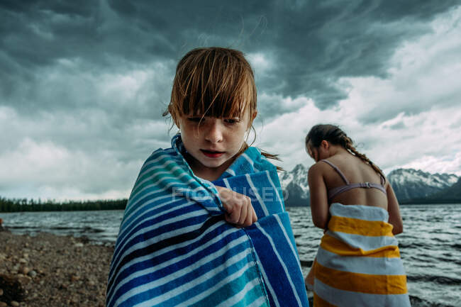 Young girls wrapped in towels near a mountain lake — Stock Photo