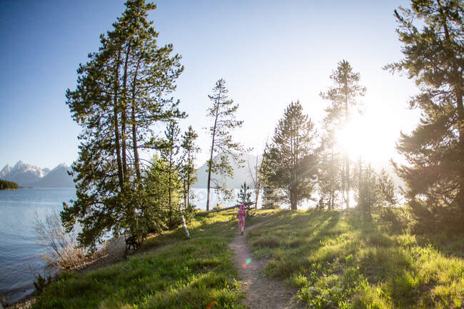 Junges Mädchen läuft an einem sonnigen Tag in Grand Tetons einen Weg entlang — Stockfoto