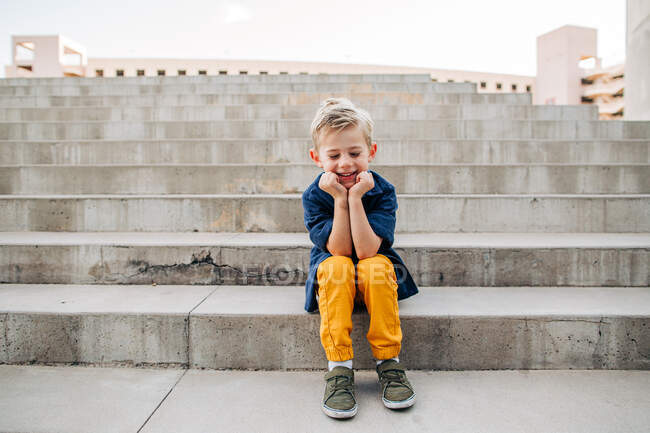 Portrait de jeune garçon riant sur des marches en béton dans le centre-ville de Phoenix — Photo de stock