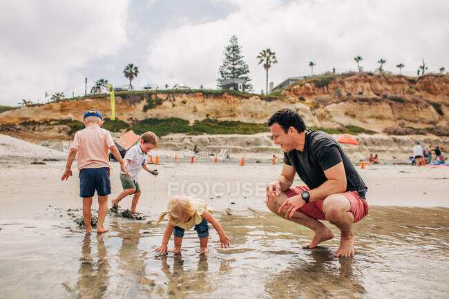 Dad plays happily with kids on Moonlight beach in San Diego — Stock Photo