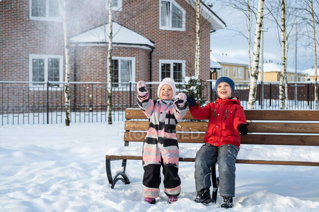 Due bambini si divertono a passeggiare nel villaggio invernale. — Foto stock