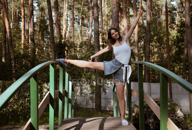 Junge Frau steht am Wochenende auf Brücke im Wald im Camp, Erholungszentrum, Öko-Hotel — Stockfoto