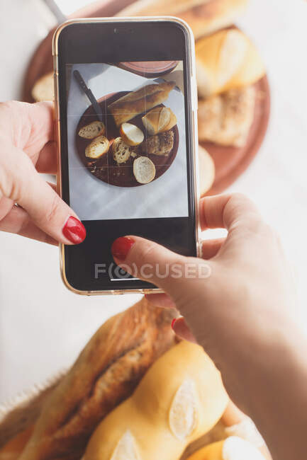 Жінка фотографує їжу зі смартфоном — стокове фото