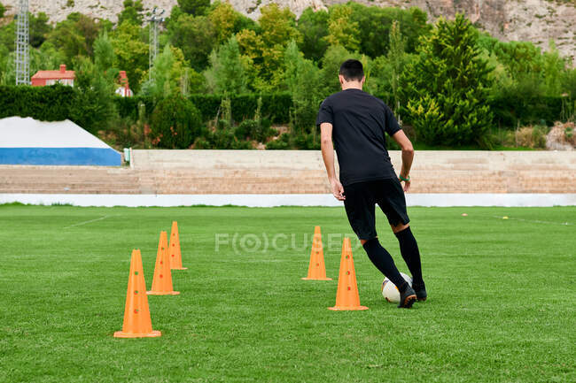 Um jogador de futebol treinando em um campo de futebol — Fotografia de Stock
