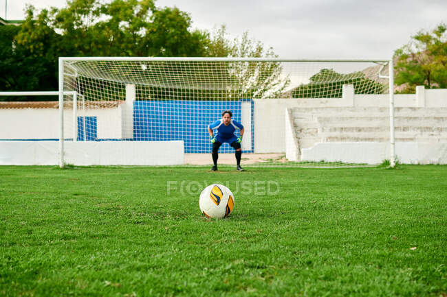 Goalkeeper in a goal ready to save a penalty shot on a football field — Stock Photo