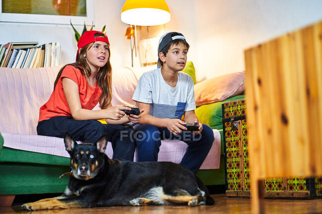 Niños jugando videojuegos en casa - foto de stock