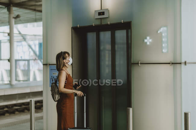 Молода жінка з рюкзаком, що йде в аеропорту — стокове фото
