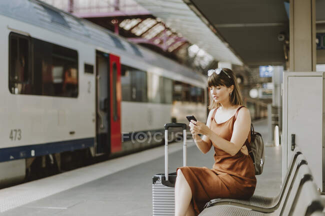 Mulher com telefone celular e trem — Fotografia de Stock