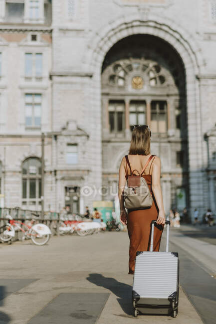 Giovane donna con valigia che cammina in città — Foto stock