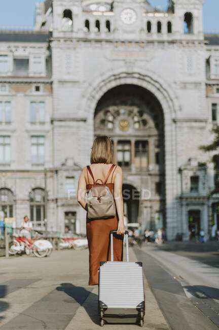 Mujer joven con mochila caminando por la calle - foto de stock