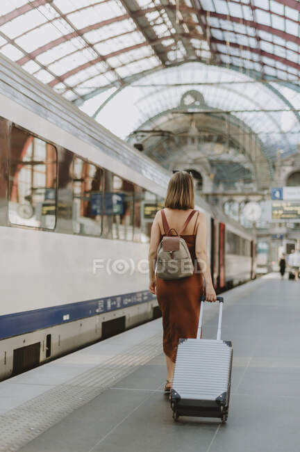 Junge Frau mit Koffer am Bahnhof — Stockfoto