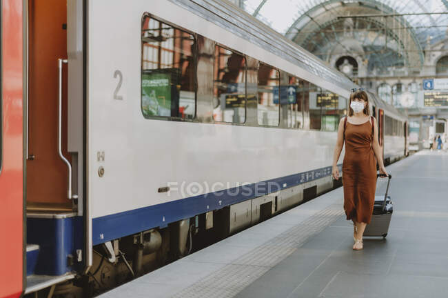 Молода жінка з багажем, що йде на станції метро — стокове фото