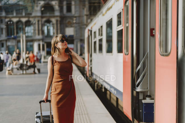 Young woman with suitcase walking in the city — Stock Photo