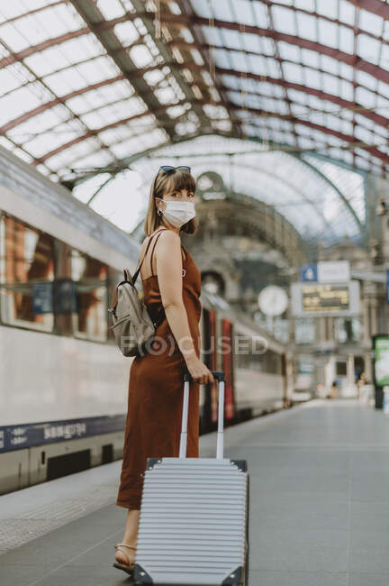 Young woman with a suitcase in the airport — Stock Photo