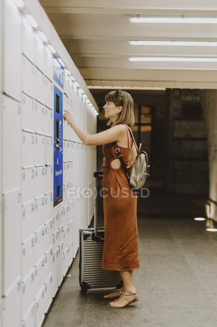 Young woman with luggage in airport — Stock Photo