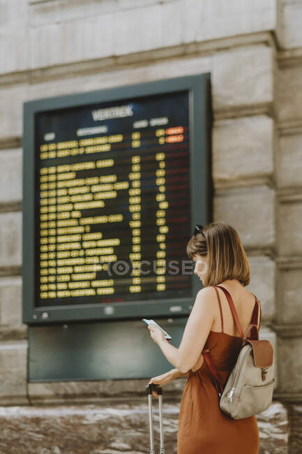 Женщина с рюкзаком и картой Парижа — стоковое фото