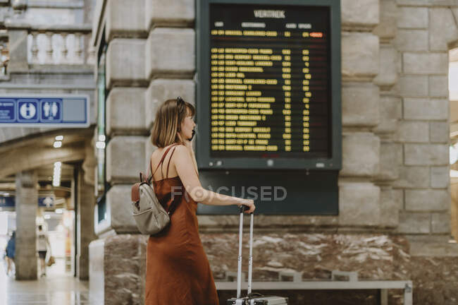 Молодая женщина с багажом в аэропорту — стоковое фото