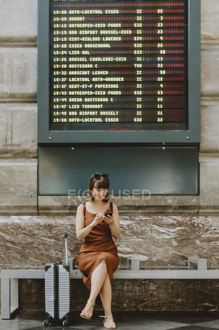 Mujer joven sentada en el suelo y mirando a la cámara - foto de stock