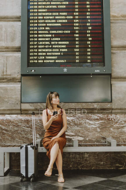 Jovem mulher sentada no chão e olhando para longe — Fotografia de Stock