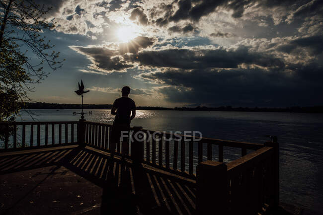 Силует людини на пірсі на заході сонця — стокове фото