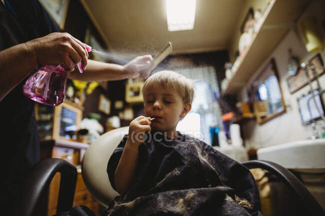 Cabeleireiro faz um corte de cabelo no salão — Fotografia de Stock