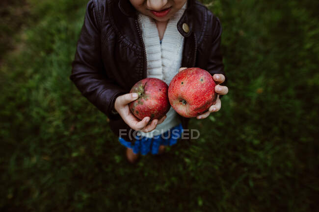 A man with a red apple in the hands of a young girl — Stock Photo