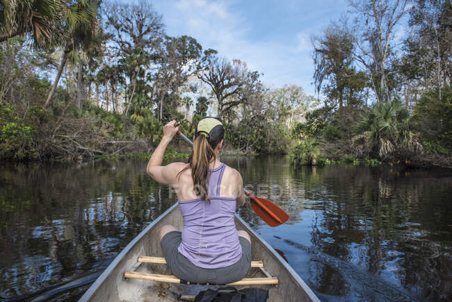 Женщина, сидящая на лодке в воде — стоковое фото