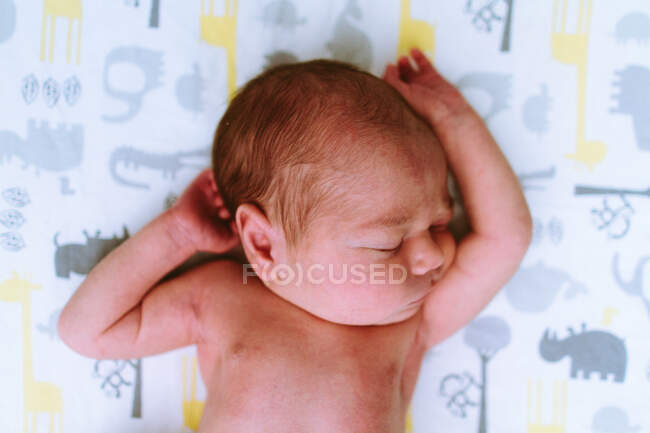 Um bebê recém-nascido deitado na cama — Fotografia de Stock
