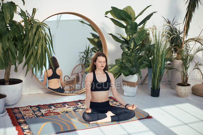 Beautiful young woman doing yoga exercises in the gym — Stock Photo