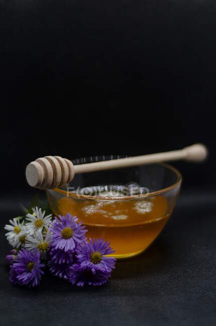 Miel et un pot de camomille fraîche, fleurs blanches et roses. — Photo de stock