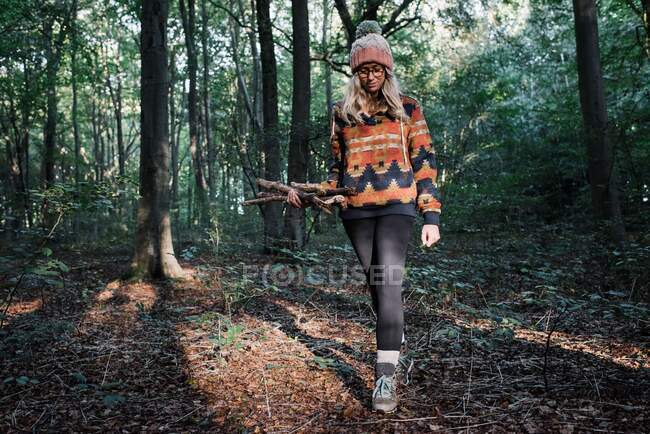 Jeune femme avec un sac à dos dans la forêt — Photo de stock