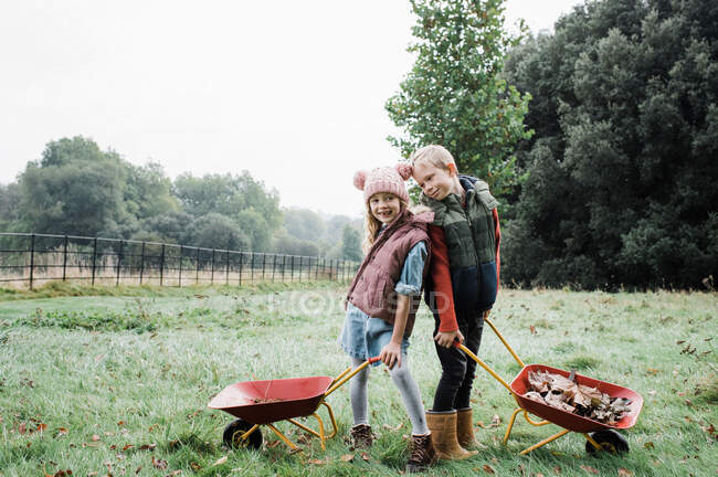 Jovem casal com uma cesta de legumes no jardim — Fotografia de Stock