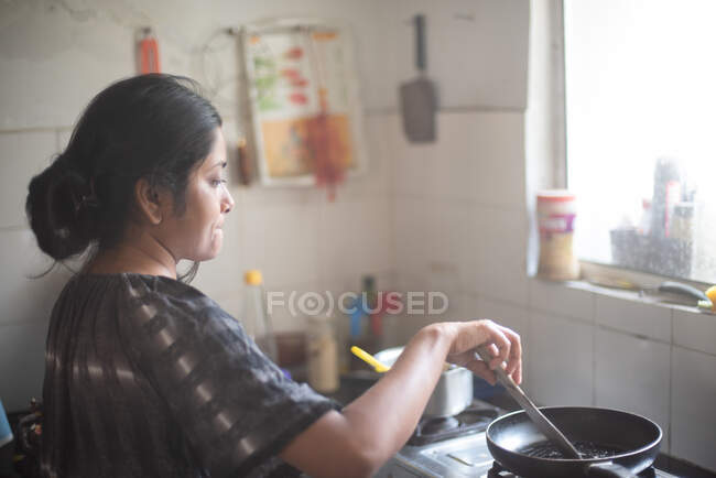 Giovane donna che cucina in cucina — Foto stock