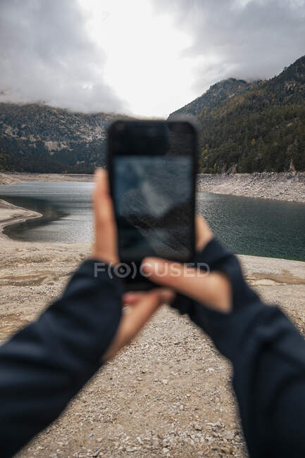 Женщина фотографирует горы со смартфоном — стоковое фото