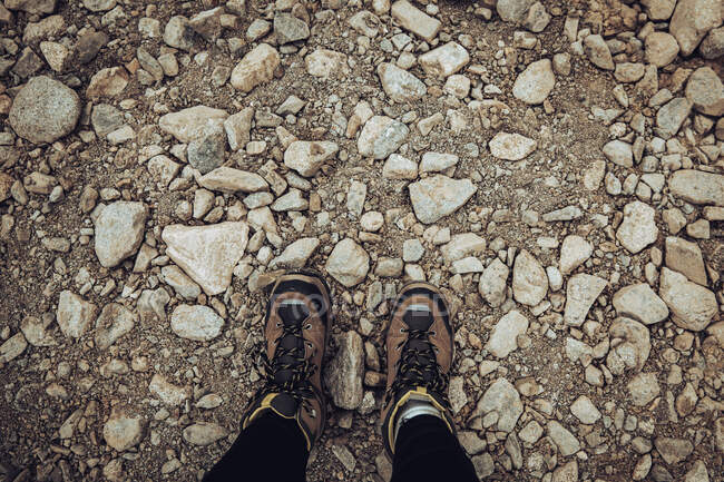 Uma visão superior de umas pernas femininas em botas na superfície rochosa — Fotografia de Stock