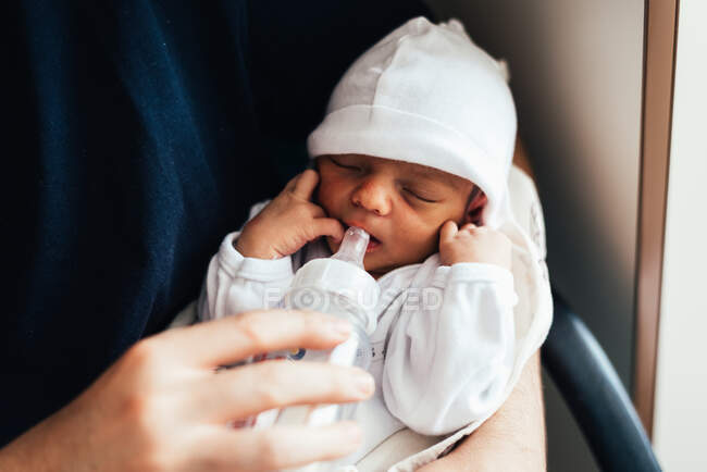 Батько годує свою новонароджену дитину пляшкою для годування . — стокове фото