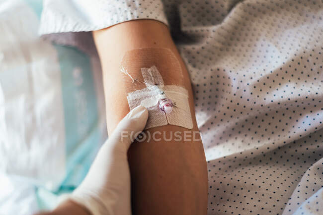 Mano del médico dando una vía intravenosa a un paciente. - foto de stock
