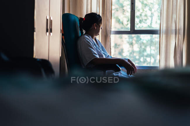 Молода жінка потрапила до лікарні. Сидячи на стільці.. — стокове фото