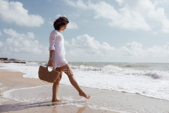 Donna libera in riva al mare, si diverte e gioca con le onde — Foto stock
