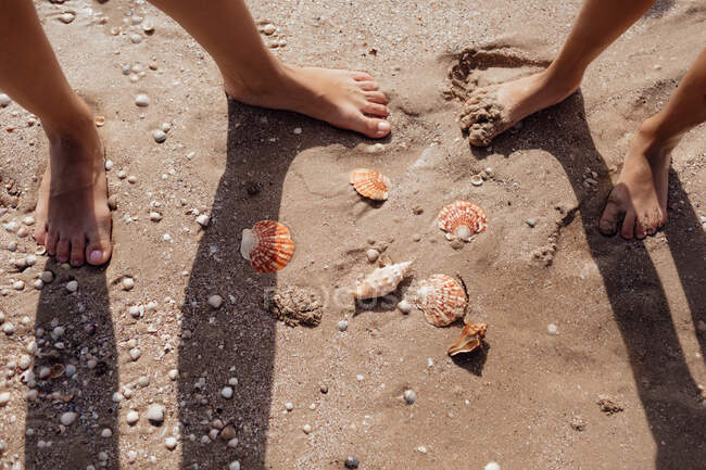 Pies de niños en la playa de arena - foto de stock